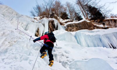 Alpinista scala una cascata di ghiaccio