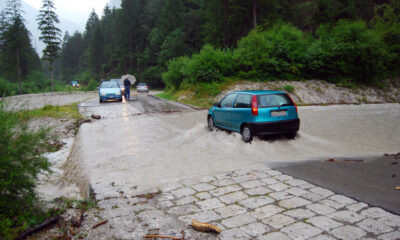 Macchina attraversa una strada allagata