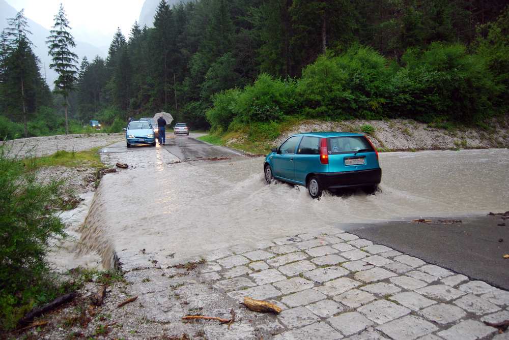 Macchina attraversa una strada allagata